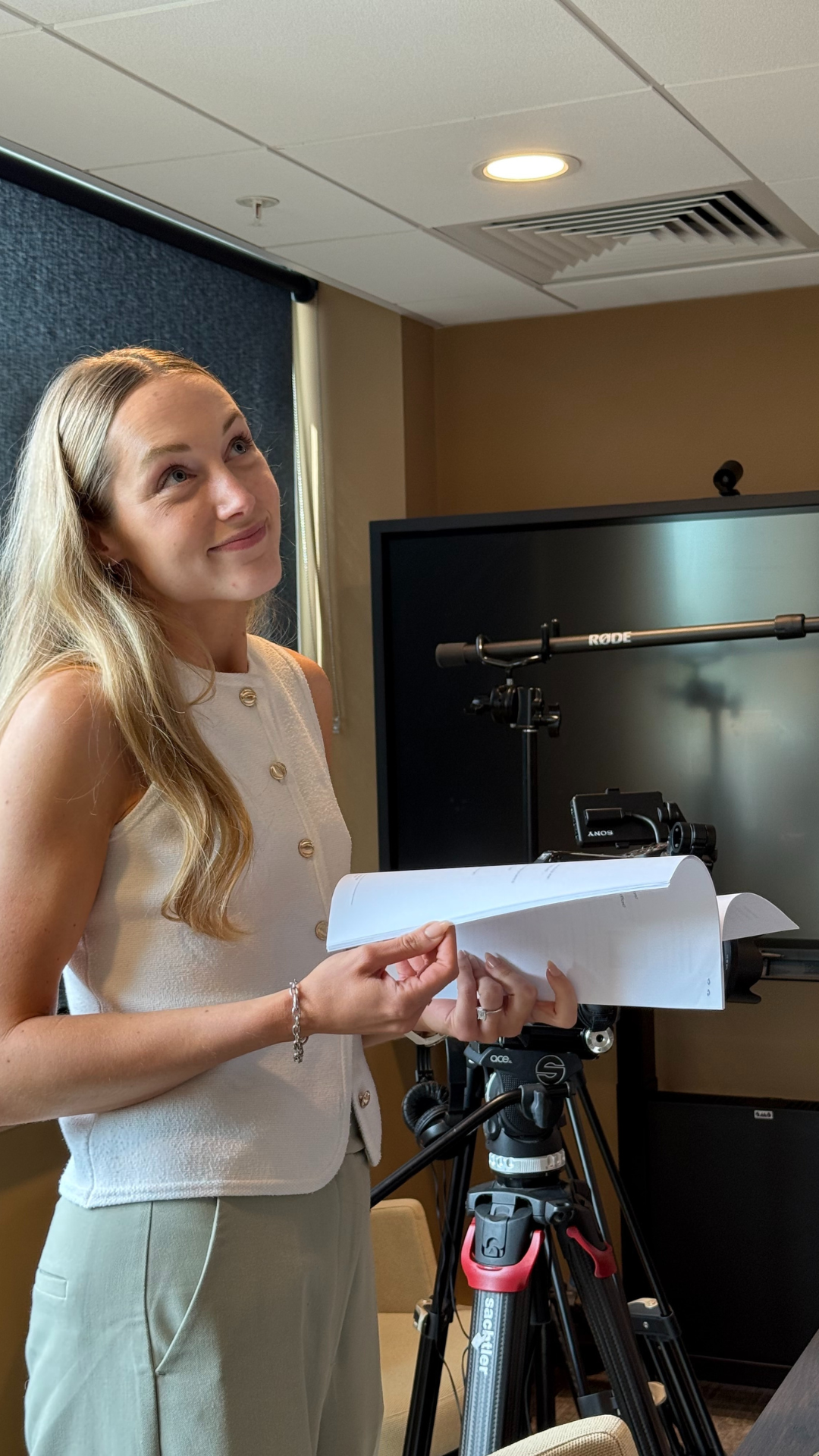 Tara smiling holding a script on set
