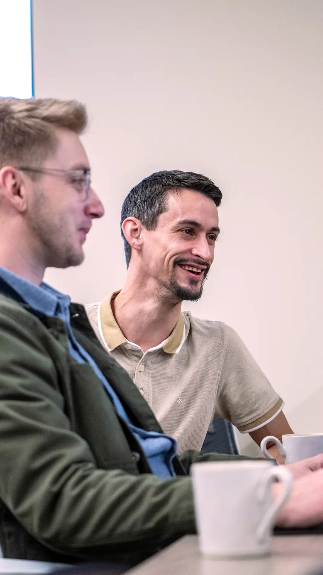 John and David smiling at their desks