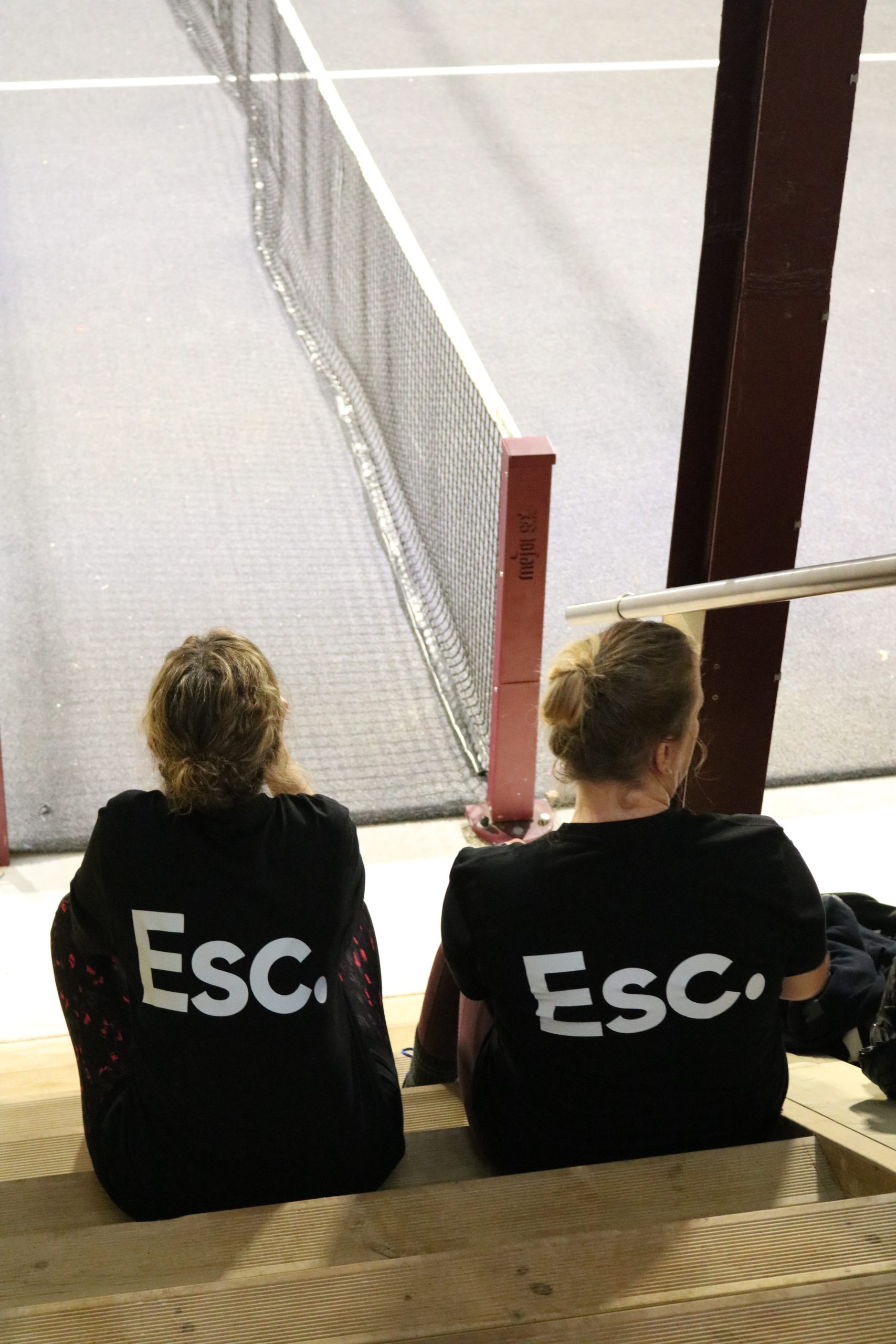Leanne and Charlotte wearing Esc. shirts on the padel court
